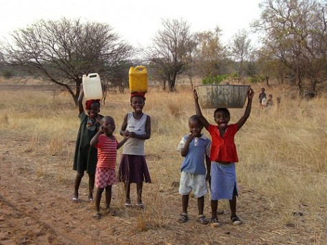 Young children carrying water home to Machenje Village